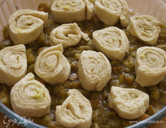 Рулет нарезать на булочки толщиной 1 см и выложить на ревень сверху