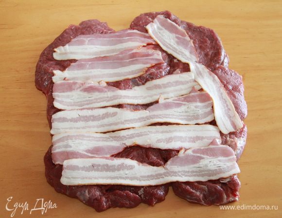 Выложить на телятину ломтики бекона,