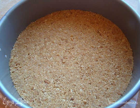 Форму 21-23 см выстилаем пергаментом, утрамбовываем аккуратно основу пирога, отправляем в холодильник и приступаем к начинке