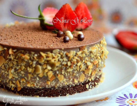 Извлечь пирожные из форм и посыпать сверху какао. Чтобы чизкейк легче отошел от формы и не деформировался, я обдула форму (бока) горячим воздухом по кругу несколько минут. Украсить клубникой, бока — дробленым и слегка обжаренным миндалем (кисточкой смазать слегка любым джемом) и маленькими шоколадными шариками.