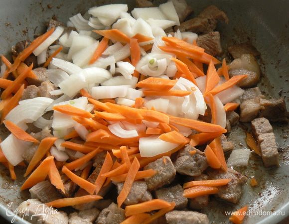 Мясо режем кубиками и выкладываем на сковородку. Жарим на оливковом масле, помешивая, пока не подрумянится. Добавляем нарезанный полукольцами-кольцами лук и соломкой морковь,  готовим на среднем огне, помешивая, около 5 минут. 