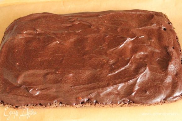 Шоколадный корж намазать шоколадным кремом и на несколько минут убрать в холодильник, чтобы шоколад застыл и держал форму.
