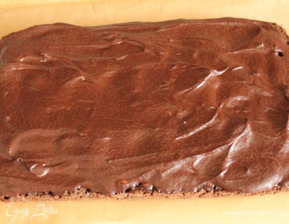 Шоколадный корж намазать шоколадным кремом и на несколько минут убрать в холодильник, чтобы шоколад застыл и держал форму.
