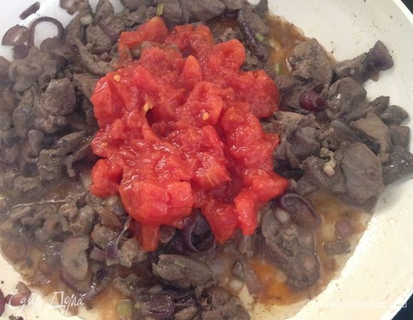 Когда печенка  будет готова, посолить, поперчить. И добавить томаты из банки (если томаты не кусочками, то просто их режем вместе с соком). Тушим примерно 5 минут, приправляем сушеным базиликом.