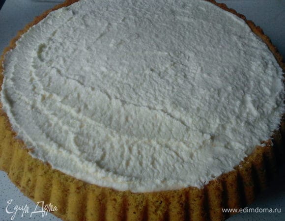 Заполнить середину коржа кремом и разрвнять его лопаточкой