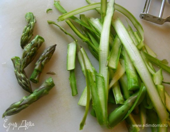 В данном салате спаржа остается в сыром виде. Для этого удаляем у нее жесткие концы. Срезаем верхушки около 3 см, а стебли режем тонкими лентами с помощью овощечистки. Если же Вы предпочитаете отварную спаржу, то с ней тоже очень вкусно получается - я для мужа так готовила. Тогда бланшируем ее до желаемой степени мягкости. 

