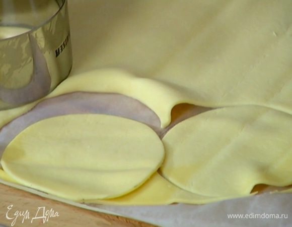 Вырезать из теста четное количество кружков и посыпать их сахарной пудрой (немного пудры оставить).