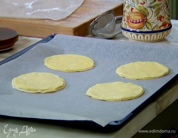 Противень выстелить бумагой для выпечки, выложить кружки из теста и часто наколоть вилкой, протыкая насквозь, чтобы тесто не слишком сильно поднялось.
