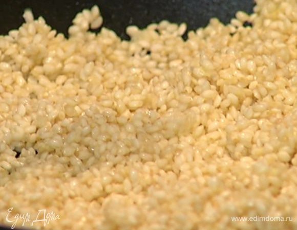 Разогреть в сковороде оливковое масло, выложить 1 ст. ложку лукового пюре, всыпать рис, перемешать и прогреть.