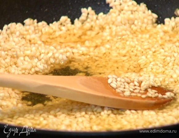 Когда рис станет прозрачным, влить 150 мл вина и дать алкоголю выпариться.