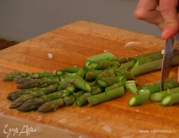 У спаржи удалить грубые черенки, разрезать на несколько частей по диагонали и добавить к рису, все перемешать.