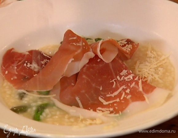 Разложить ризотто в тарелки, сверху выложить по нескольку ломтиков ветчины и посыпать оставшимся сыром.