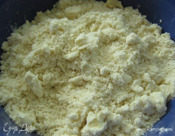 Затем добавляем масло из морозилки, еще раз растираем все в крошку, добавляем сначала 3 ст.л. жидкости, растираем и потом добавляем по 1 ст.л. Чем меньше жидкости уйдёт на то, чтобы сформировать шар, тем лучше.