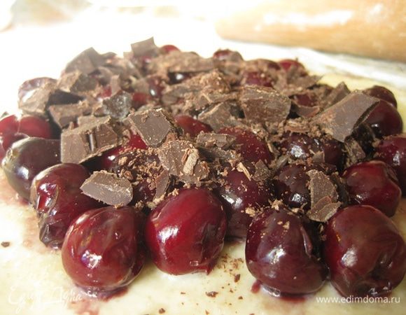 Шоколад нарезаем на небольшие кусочки. Молоко и белок смешиваем вместе.
Достаем тесто, отщипываем где-то 1/5 или 1/6 часть, остальное убираем обратно в холодильник. Раскатываем круг, не сильно тонко, смазываем его молочной смесью, посыпаем щепоткой сахара, выкладываем черешню и сверху шоколад.Края защипываем прижимая к черешне. Сверху так же смазываем молочной смесью и посыпаем сахаром. Получившуюся галету кладем в морозилку. Так проделываем со всеми галетами. У меня получилось 6 штук диаметром около 10 см.