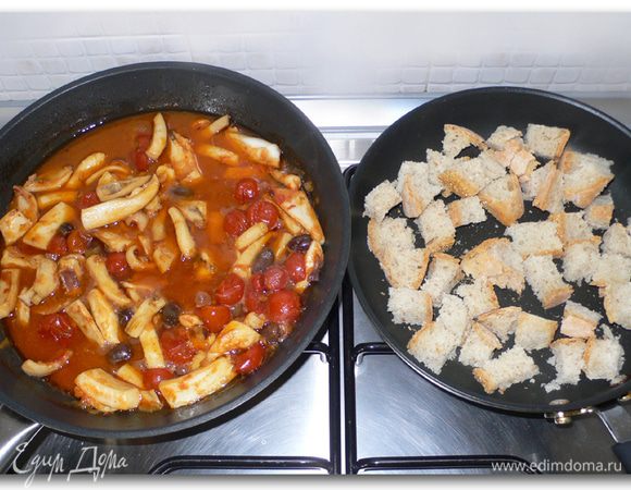 На отдельной сковороде подрумяниваем без масла белых хлеб, нарезанный кубиками. В другую , с луком и помидорами, которые уже к этому времени  пустили сок,  помещаем кусочки каракатицы и заливаем вином. Мне пришлось добавить томатного пюре. 
Спустя пару минут добавляем маслины, перец, соль.  
Тушим каракатицу около 30 минут под приоткрытой крышкой.
Если жидкости слишком много, крышку можно снять.  