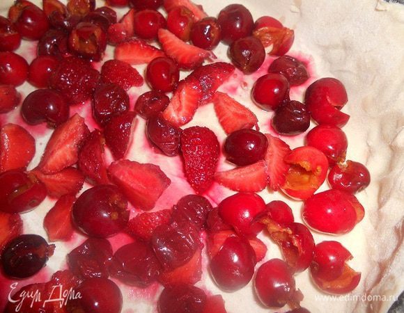 Слоеное тесто перенести в форму, излишки теста убрать, на тесто выложить ягоды. Тем временем сделать сливочный крем -  яйцо растереть со 110 г сахара, добавить крахмал и перемешать, влить сливки, перемешать и проварить на водяной бане до 60 градусов.