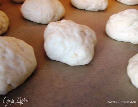 






Когда тесто подойдет, обминаем его и снова даем подойти. Снова обминаем, делим на 12 (примерно) частей, формируем шарики, кладем на застеленный бумагой для выпечки противень и даем еще раз подойти уже каждому шарику.