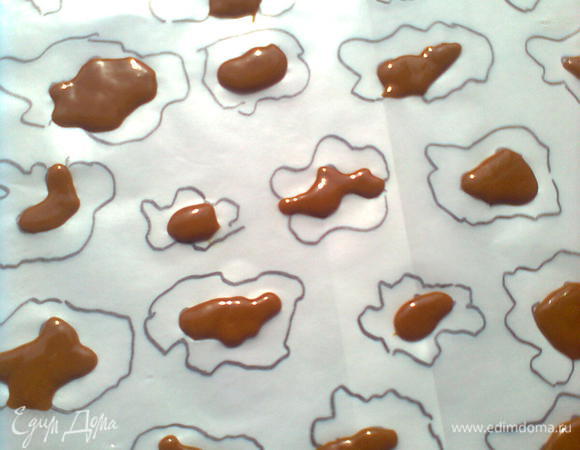 Перевернуть лист на изнаночную сторону, подложить белую бумагу для четкости и с помощью кулинарного шприца нанести внутренние узоры желтым тестом.