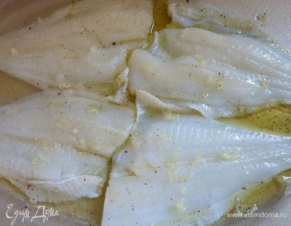 Уложить сверху рыбку и полить одной ложкой масла, третью чеснока и солью с перцем .