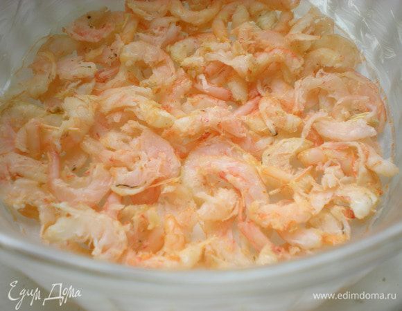 Подготовить форму. Дно застелить бумагой для выпечки и смазать посуду  сливочным маслом. На бумагу выкладываем первую часть разрезанных пополам креветок. 





