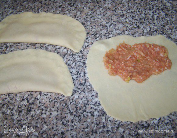 Берем кусочек теста, раскатываем тоненько скалкой (тесто очень поддатливое и даже не требует муки, для посыпки на стол) на одну половину теста, выкладываем фарш, примерно 1,5 ст.л., накрываем второй половиной теста и крепко залепить край.