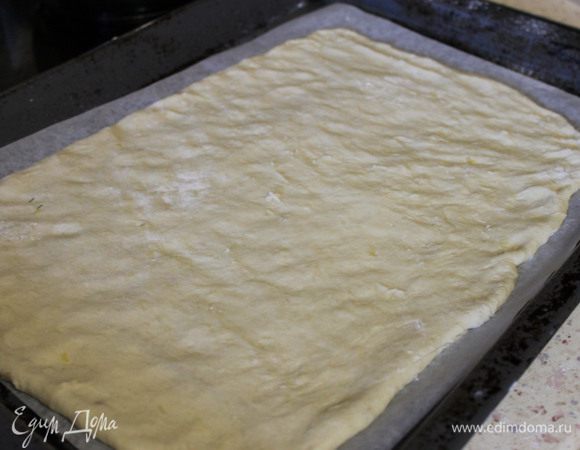 1. Противень застелить пергаментом и слегка смазать растительным маслом. Достаем тесто из холодильника, выкладываем на противень и разминаем по периметру формы, пальчиками. Чтобы тесто не липло к рукам, опускаем иногда пальцы в муку.
