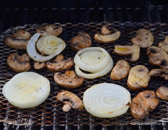 Рибай и лук смажем оливковым маслом. Посолим и поперчим. Выложим лук и грибы на разогретый гриль и готовим 10 мин. примерно грибы и 14 мин. лук.