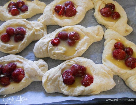 Сложить разрезанные края лепешки на противоположные стороны и получится лодочка как на фото, в серединку положить клубничку и полить медово-масляной заливкой (по 1 ч. л. примерно), оставшейся заливкой смазать края лодочек. Выпекать при температуре 170 градусов до золотистого цвета.