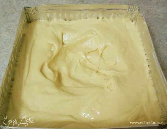 Форму для выпечки смазать маслом и выстлать пергаментом.(Можно выпекать и в прямоугольной, но потом пожертвовать частью кекса, обрезав до квадрата)
Ложкой выложить тесто в форму, разровнять и сделать в центре углубление для более равномерного выпекания.