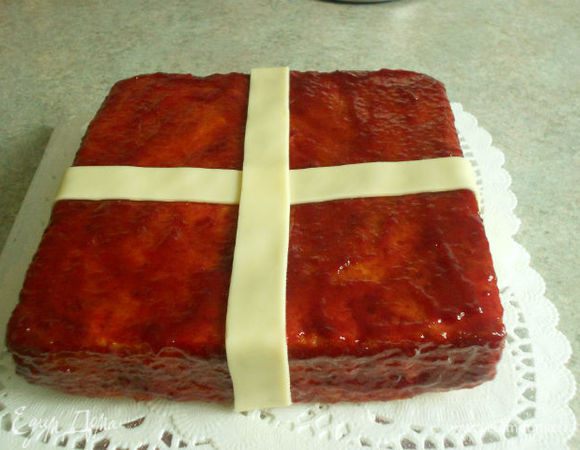 Малину помыть и обсушить.
В сотейнике  на маленьком огне нагреть малиновый джем до расплавления. Кистью обмазать верх и бока кекса, стараясь нанести как можно более толстый слой особенно на бока.

Две длинные ленты перенесите на кекс, перекрещивая их по центру  и опуская по бокам. Осторожно прижать.