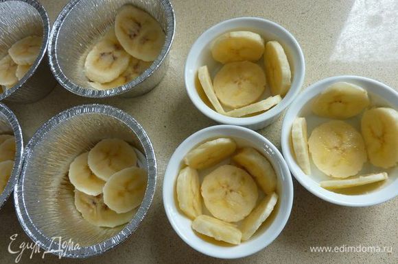 В восемь маленьких (для детей использую одноразовые, потому что керамические быстро разбиваются) формочек укладываем кусочки банана.