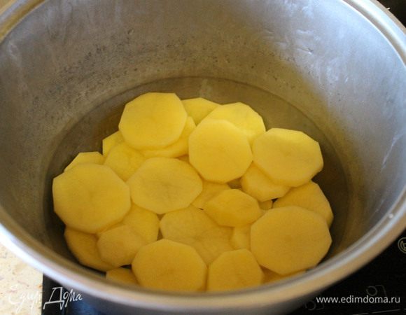 Берем кастрюлю среднего размера, смазываем растительным маслом. Картофель очищаем и режем кружочками примерно 3-4 мм, и укладываем в кастрюлю ровным слоем, посолить слегка.