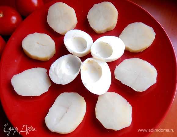 Раскладываем на большом блюде картофельные ломтики и белки...