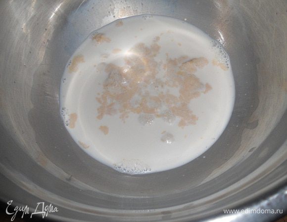 Сливки перемешать с водой, половину отлить в другую миску. В первой миске развести дрожжи, добавив щепотку сахара и оставить постоять 5 минут.