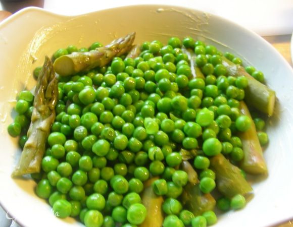 Разогреваем духовку до 200 гр. Спаржу режем маленькими кусочками. Бланшируем ее и зеленый горошек несколько минут в подсоленой воде. Сливаем воду и откидываем на сито. Можно их обдать холодной водой для сохранения цвета. Выкладываем их в порционную форму для запекания, смазанную маслом