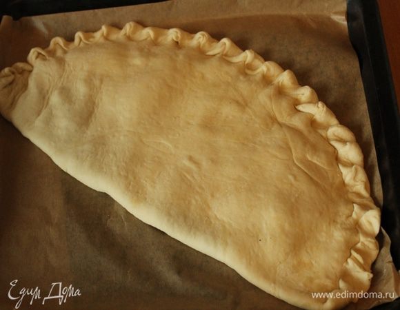 Края защипнуть. Выложить пирог на выстланный пергаментом противень и выпекать 15-17 минут...