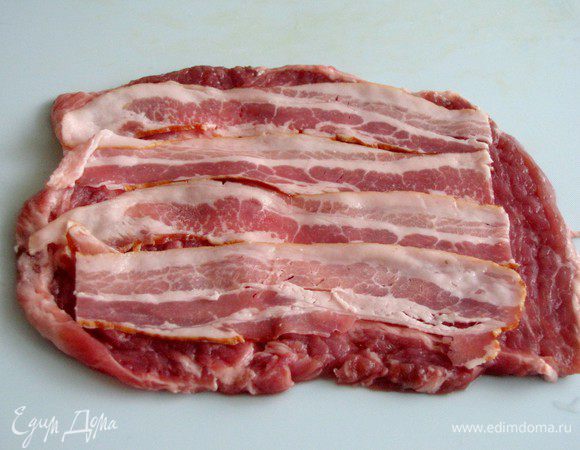 Ломтик отбитого мяса посолите и поперчите. Выложите на него бекон. Если бекон достаточно соленый, то мясо можно не солить.