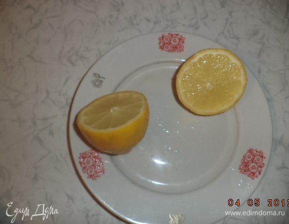 Луковицу разрезать пополам и вложить половинки в лимонные чашечки. Положить эти чашечки вместе с чесноком в курицу. Выложить курицу в форму для запекания.