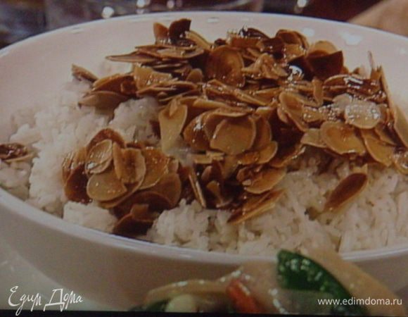 Миндальные лепестки подрумяниваем на разогретом сливочном масле и выкладываем на отваренный рис.