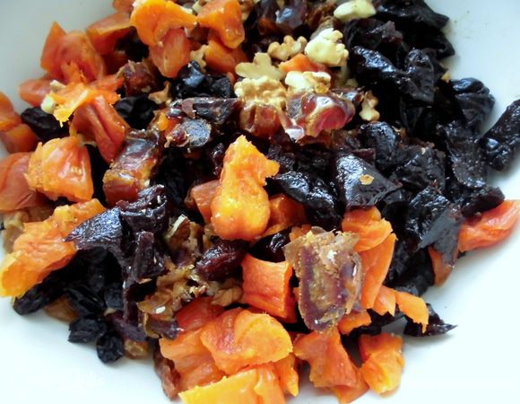 Изюм помойте и хорошо просушите. Из фиников удалите косточки. Нарежьте все сухофрукты и орехи довольно крупно (арахис нужен для приготовления обсыпки).