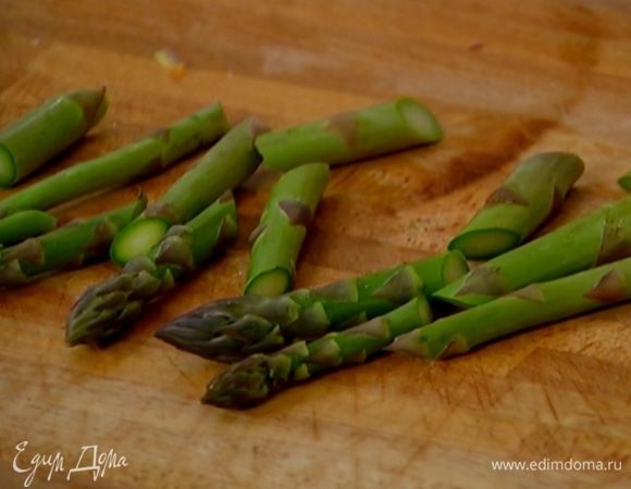 Со стеблей спаржи срезать грубые черенки и разрезать каждый на несколько частей наискосок, затем сбрызнуть оставшимся оливковым маслом, посолить и поперчить.