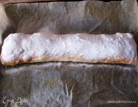 Расстилаем на столе хлопчатобумажное полотенце размером 50*70 см, обильно посыпаем его мукой (у меня ушло 25 г). Раскатываем тесто как можно тоньше, смазываем его раст. маслом. Подкладываем под него руку ближе к центру. И начинаем растягивать во все стороны. Фотографировать процесс я физически не смогла, простите.  Теста как раз хватило на размер полотенца. Оно стало такое тонкое, что был очень хорошо виден рисунок. В процессе вытяжки тесто необходимо несколько раз смазать раст. маслом. Далее смазываем тесто растопленным сливочными маслом, выкладываем крошки, посыпаем сахаром и корицей. Затем миндаль. Вишню равномерно. Края необходимо оставить свободными. Загибаем их внутрь, и с помощью полотенца сворачиваем штрудель. Переносим его застеленный бумагой для выпечки противень с помощью полотенца швом вниз. Смазываем растопленным сливочным маслом. Накрываем фольгой и отправляем в разогретую до 200 гр. духовку на 15 мин.  Затем фольгу убираем, смазываем маслом или сливками и печем еще 20-25 мин.