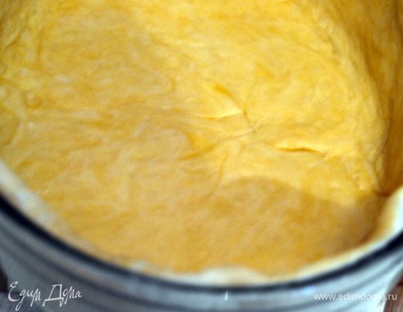 Замесить тесто,выдержать его для подъема в теплом месте,без сквозняков. Затем на подпылённой поверхности раскатать два пласта. Один чуть больше другого. Выложить больший в форму, смазанную маслом. Сделать бортики.