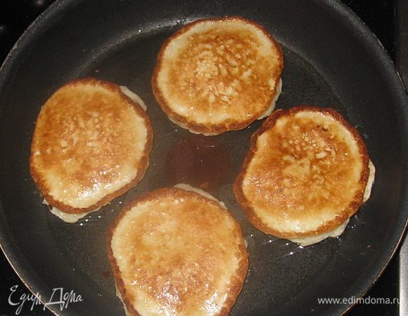 Готовые оладьи полить сметаной и вареньем, украсить черникой. 