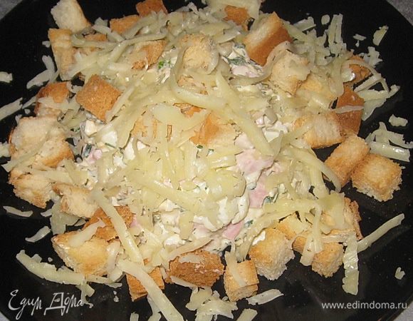  В порционную тарелку выложить салат горкой, посыпать сыром и сухариками. 