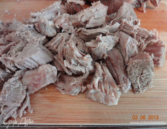 Готовое мясо вынуть из бульона, чуть остудить и порезать на небольшие кусочки.