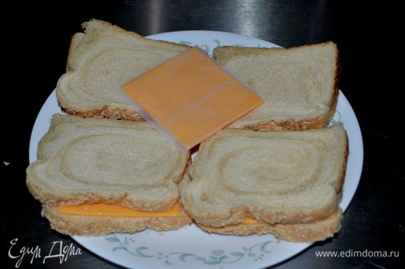 В это время обжариваем хлеб в тосторе. Выкладываем сыр пластинками, закрываем другим кусочком хлеба и ставим в микроволновку на 1 мин.