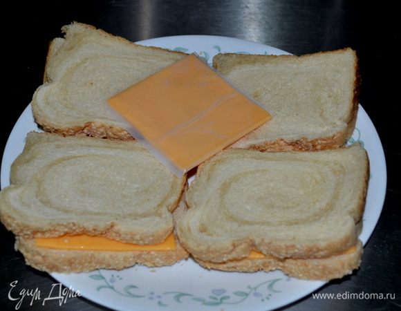 В это время обжариваем хлеб в тосторе.  Выкладываем сыр пластинками, закрываем другим кусочком хлеба и ставим в микроволновку на 1 мин.