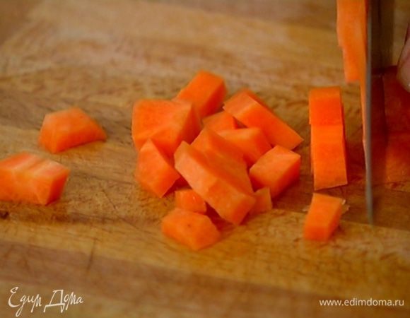 Морковь почистить, нарезать кубиками, отправить в сковороду с луком и чесноком, все перемешать.