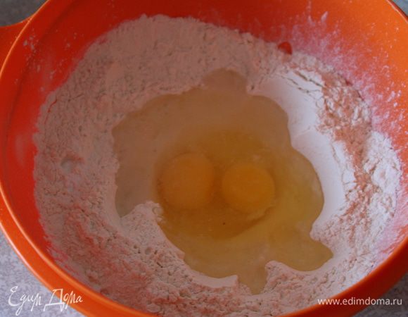 Замесим тесто. Муку просеем и сделаем углубление в середине. Туда выльем 60 мл воды, яйца, соль, соду и растительное масло.
